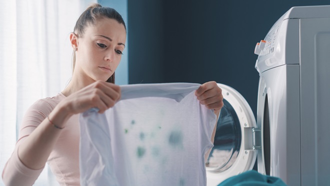 woman looking at stained laundry